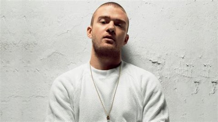 Justin Timberlake leaning against a purple wall